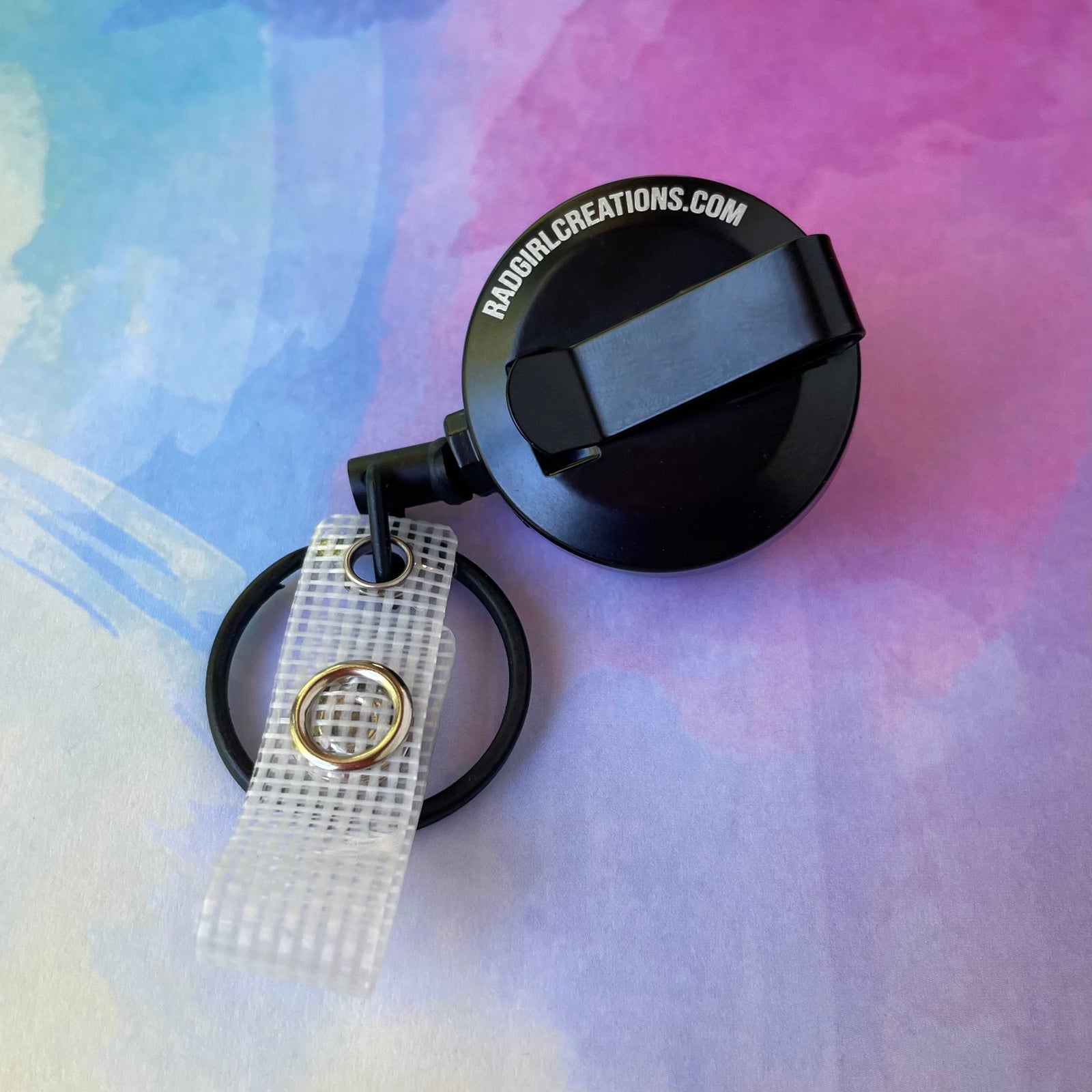 Retractable badge holder with lanyard on a light gray background