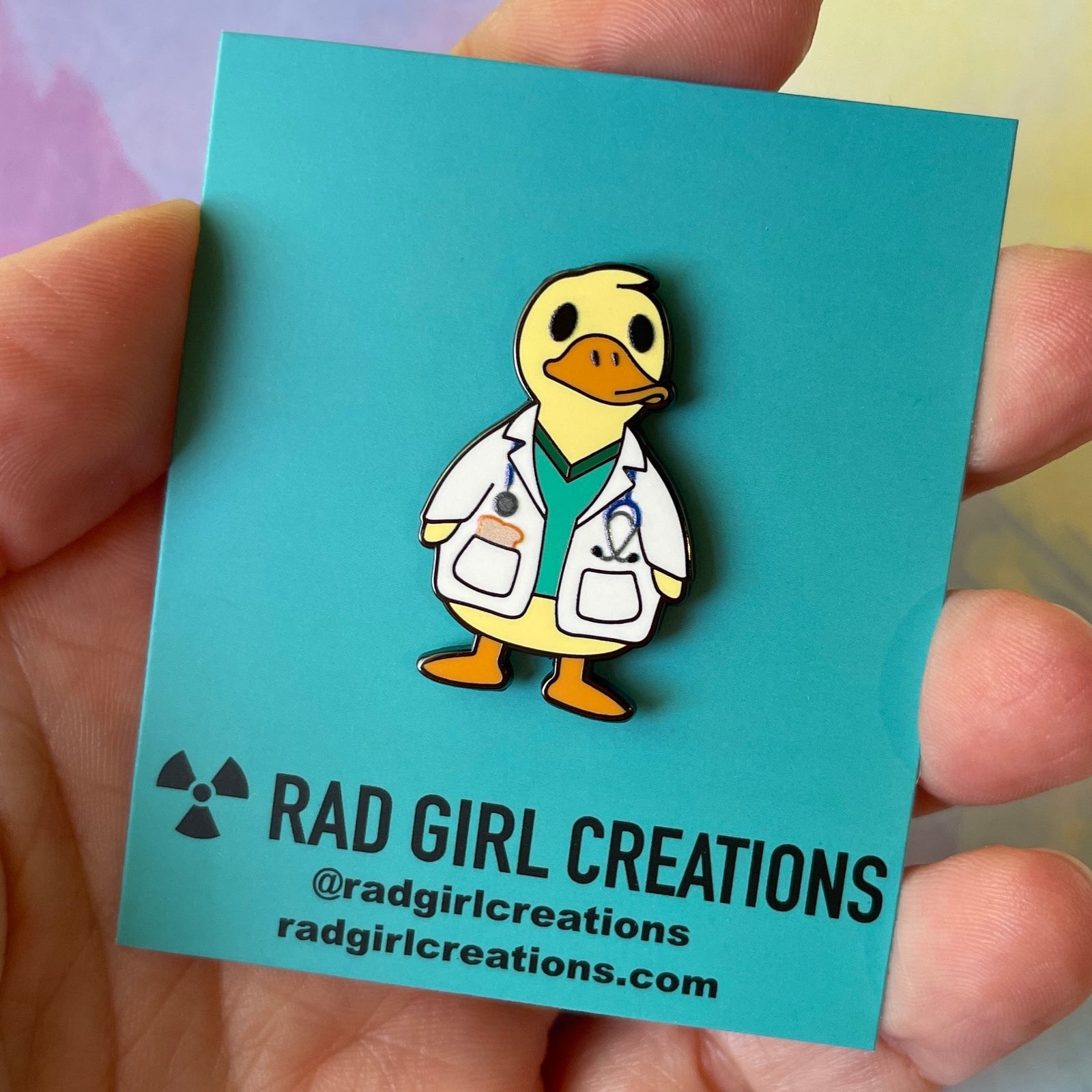 Cartoon duck character enamel pin wearing a doctor's outfit on a gray background
