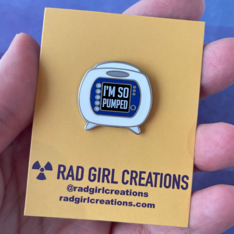Enamel pin with retro pump design and 'I'm So Pumped' text on a gray background
