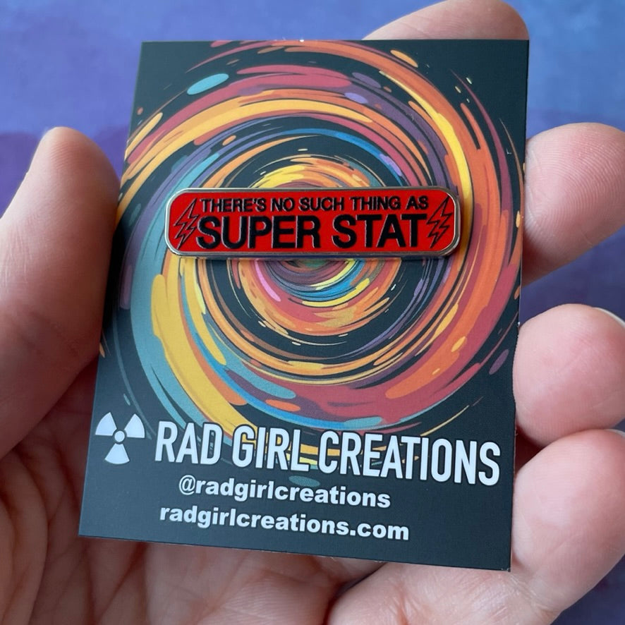 Red and black enamel pin with text on a gray background
