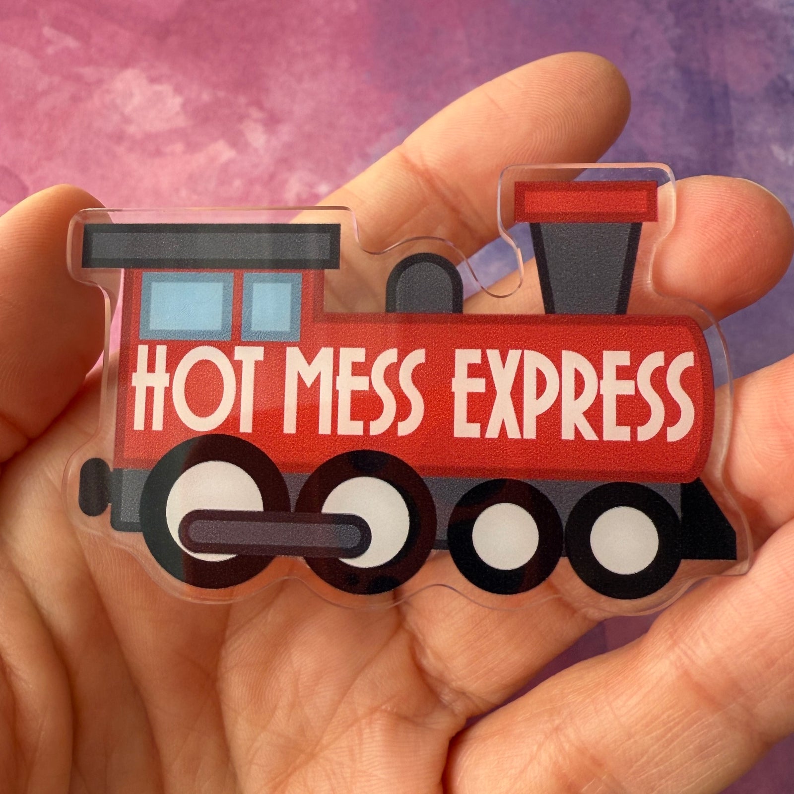 Badge reel of a red train engine with 'Hot Mess Express' text on a light gray background
