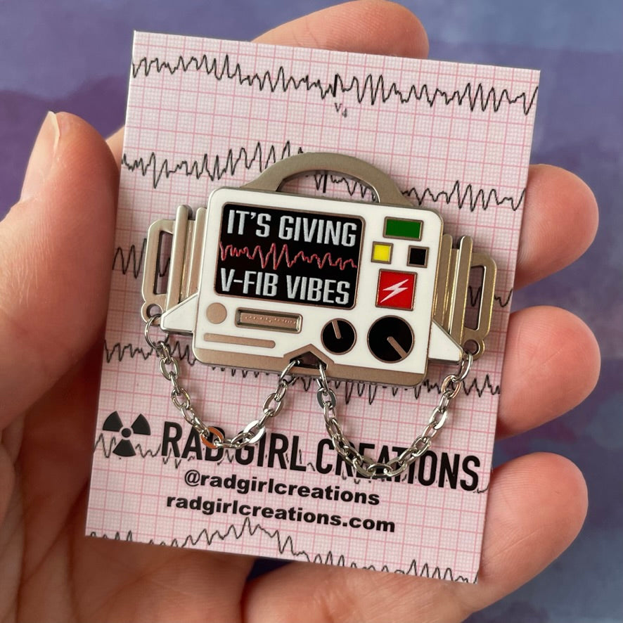 Vintage-style radio-themed accessory with 'It's Giving V-Fib Vibes' text on a gray background