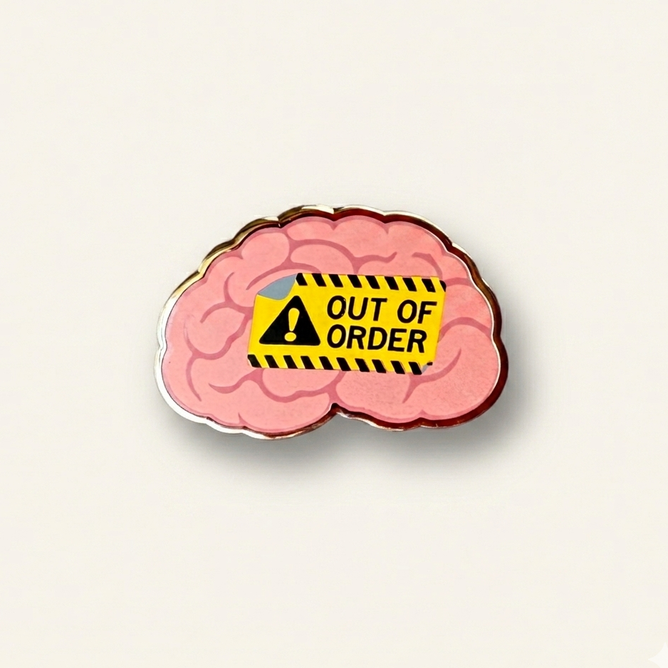 Enamel pin of a pink human brain featuring a yellow 'Out of Order' warning sign with a black exclamation point, set against a solid white background.